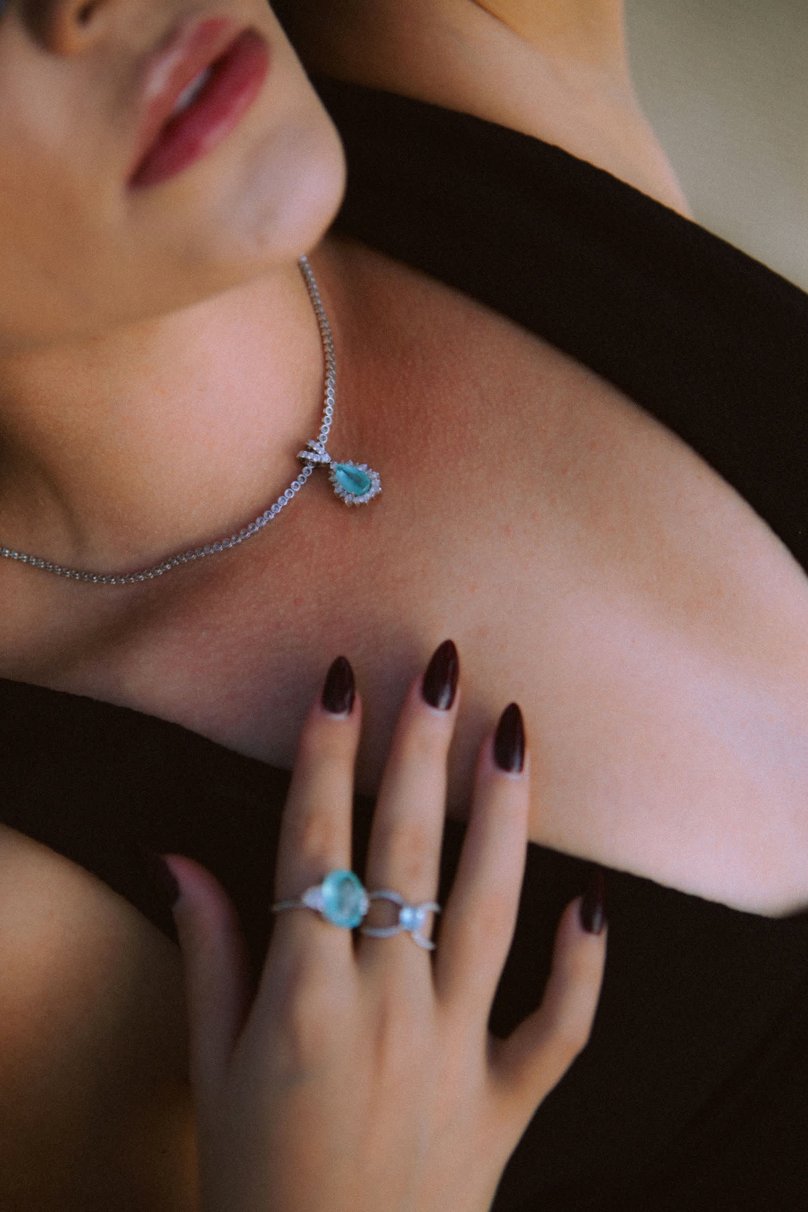 Ocean Ring — An oval Paraíba tourmaline flanked by two trillions.