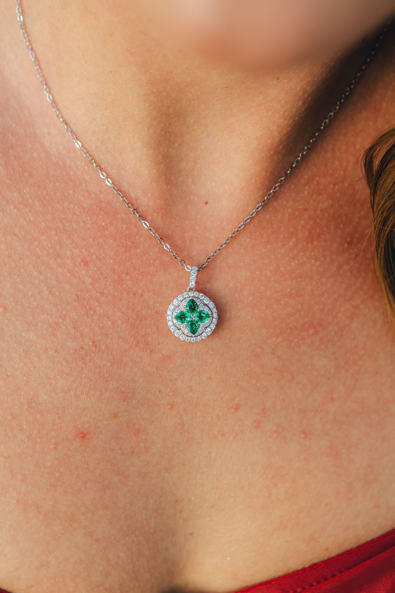 Clover Pendant — An emerald clover inside a round double halo.