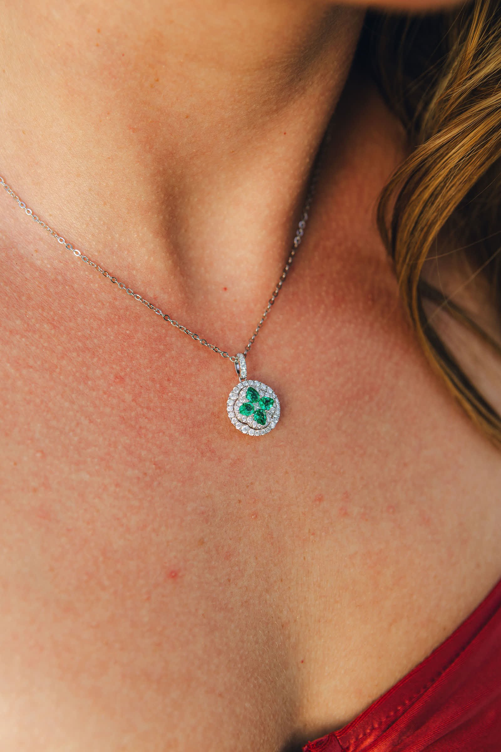 Clover Pendant — An emerald clover inside a round double halo.